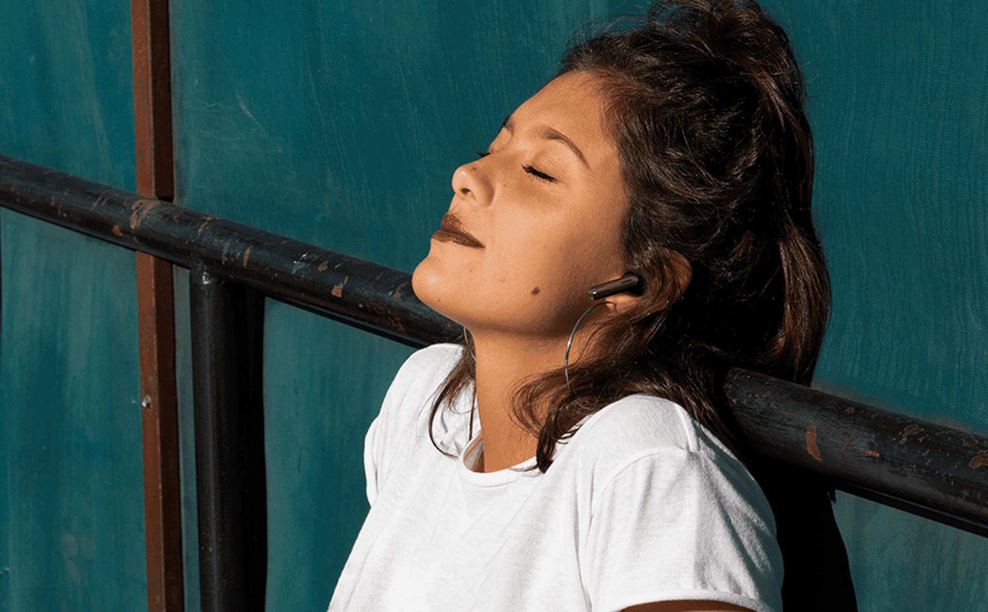 Woman wearing JBL Tune Beam Earbuds