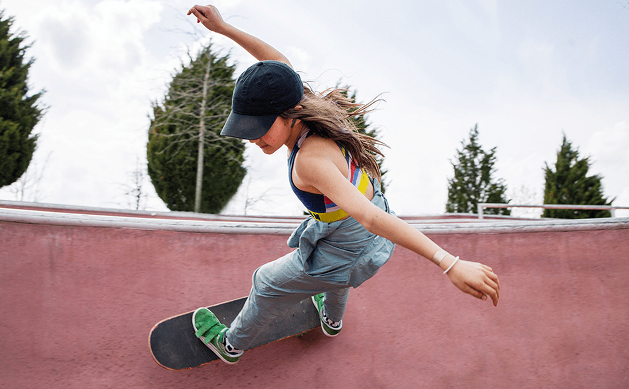 Woman skateboarding with JBL Wave Flex